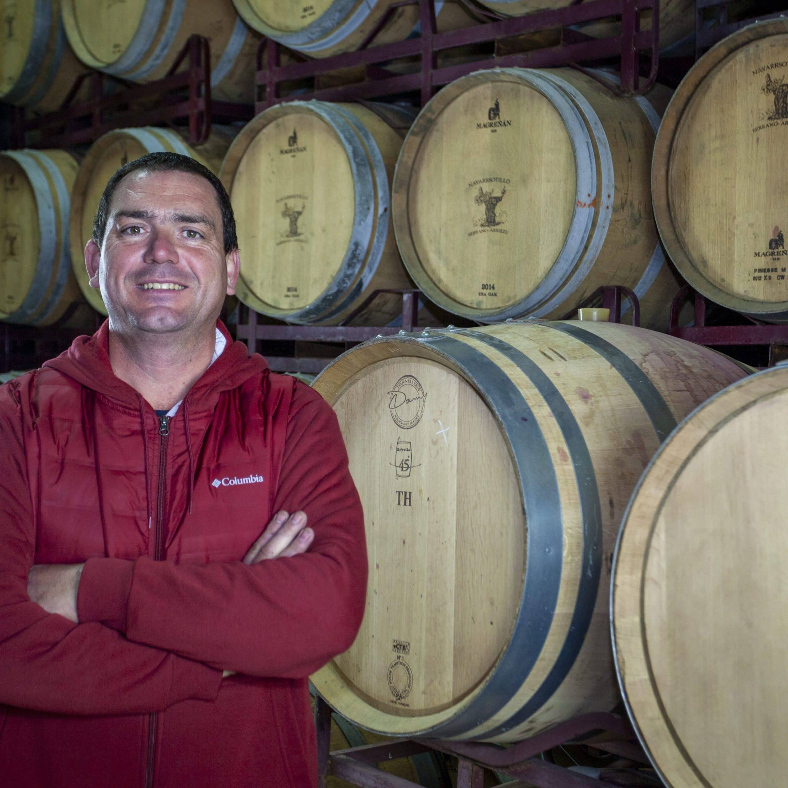 wine maker with wine barrels in background